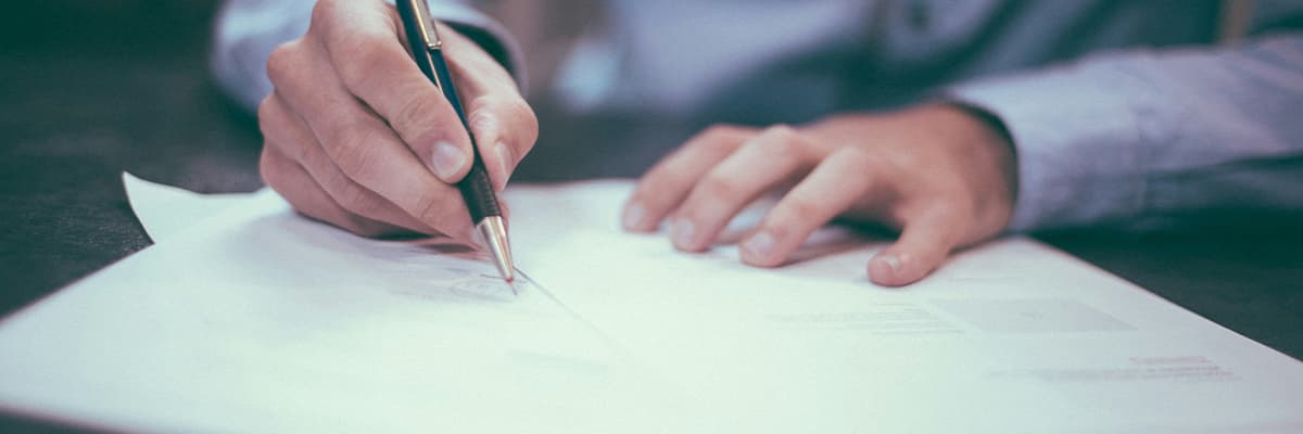 A person reviewing and signing paperwork