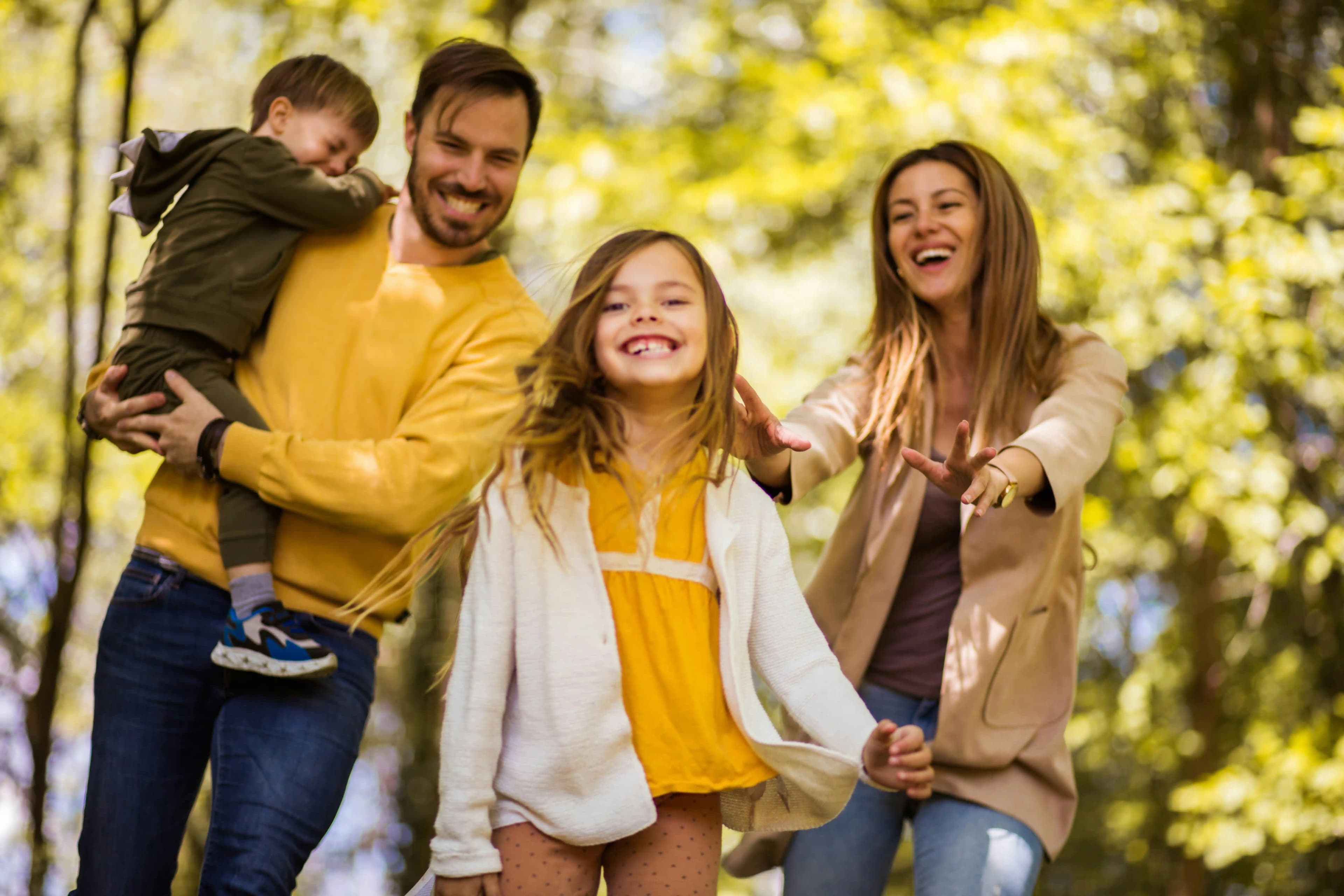 A smiling family walking together outdoors in autumn